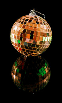 Christmas mirror ball isolated on the black reflective surface;