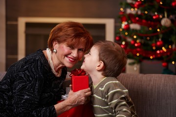 Small boy getting christmas present from grandmother