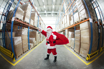 Santa Claus + sack , ringing in a bell in storehouse + gifts - obrazy, fototapety, plakaty