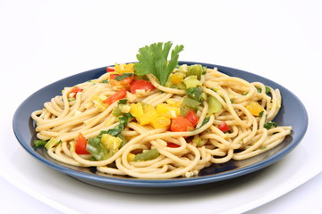 Spaghetti with vegetables on a plate on white background