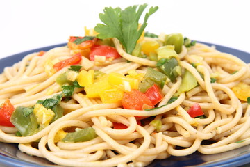 Spaghetti with vegetables on a plate in close up