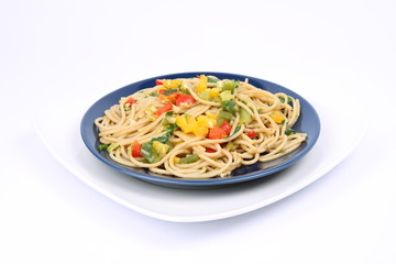 Spaghetti with vegetables on a plate on white background