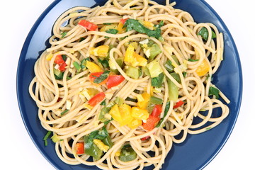 Spaghetti with vegetables on a plate on white background