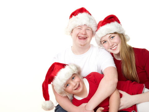 Three kids dressed up as Santa Claus have fun