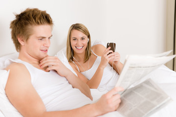 Young couple relax in bed listen to music