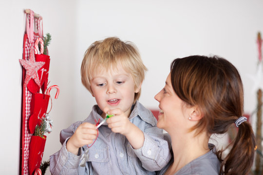 mutter mit glücklichem kind vor dem weihnachtsgeschenk