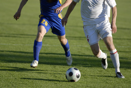 Photo of soccer players with ball in action