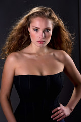 Naklejka premium Portrait of a gorgeous young woman with curly long hair