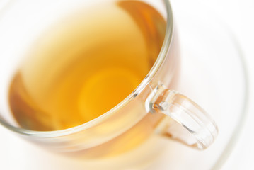 Transparent cup of tea on white