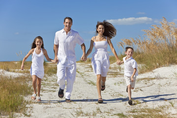 Mother, Father and Children Family Running Having Fun At Beach