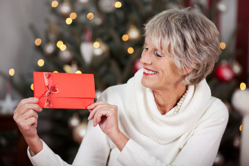 lächelnde ältere frau mit gutschein