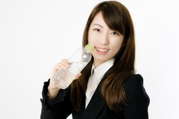 ペットボトルで水を飲む女性社員