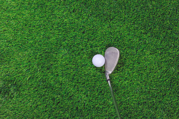 Golf ball and iron club on grass - obrazy, fototapety, plakaty