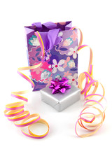 bag with gift and party streamer over white background