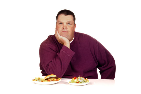 man thinking what to eat between a cheeseburger meal and a salad