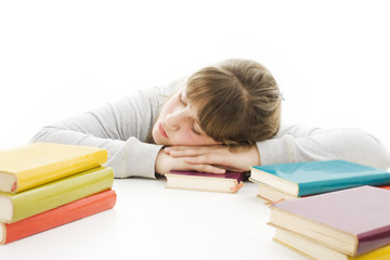 Teenage girl studying at the desk being tired.