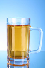 Mug of beer on blue background