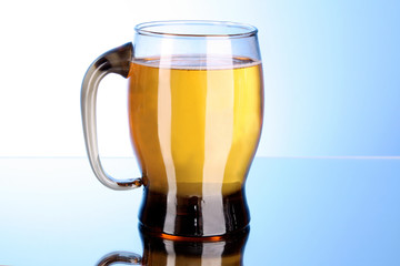 Mug of beer on blue background
