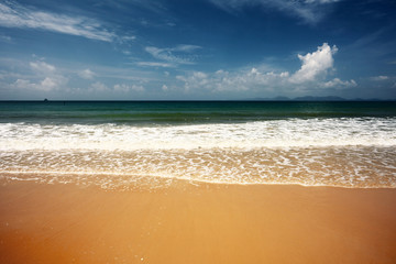 The sea with clear water yellow fine sand and sky with fluffy clouds