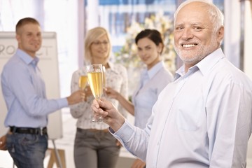 Senior businessman raising champagne glass