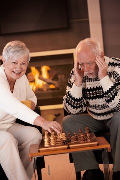 Couple playing chess in cosy living room