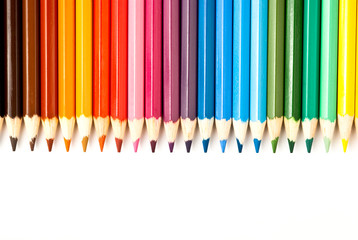 Color pencils in a row over white