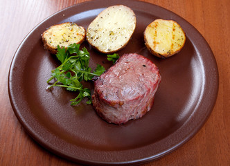 Grilled beef on white plate with potatoes