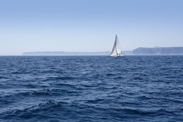Obraz premium Blue sea with sailboat sailing the ocean surface