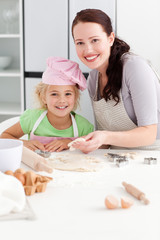 Obraz na płótnie Canvas Portrait of a happy mother and daughter kneading a dough