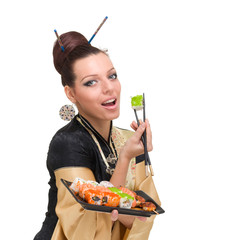 Young woman wearing a traditional dress eating sushi, isolated