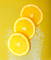 Fresh orange dropped into water