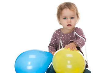 Fototapeta na wymiar Little girl holding yellow and blue balloons