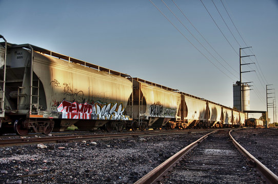 Urban landscape photo of train cargo with graffiti.