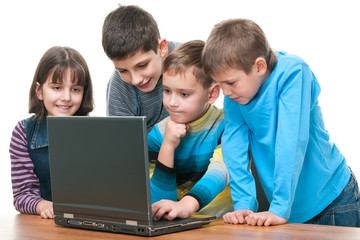 Four children studying using a laptop