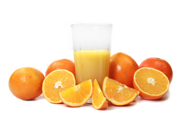 Fresh oranges with glass of juice on white background