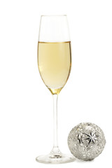 ein glas mit champagner mit einer metallenen christbaumkugel