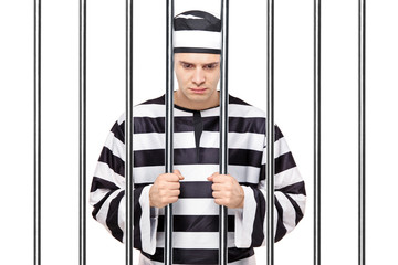 A sad prisoner in jail holding bars