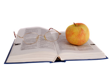 apple and glasses on the book