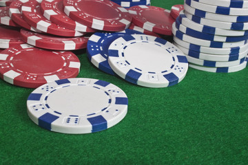 scattered poker chips on a green beize