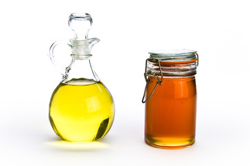 Fancy glass containers of oil and honey on isolating background