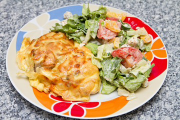 chicken breast baked under cheese with salad