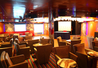 Interior of cafe with armchairs and tables on cruise ship
