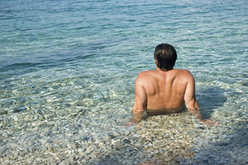 Fototapeta na wymiar Man sitting in the sea and relaxing.