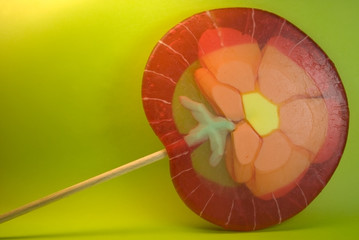 A lollipop with a flower pattern against green background
