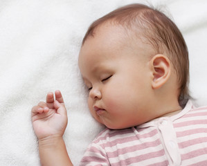 little girl sleeping on a white towel