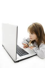Beautiful little girl lying on floor with a laptop,