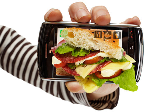 hand holding cell phone with open sandwich