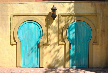 A pair of african style doors on a yellow house