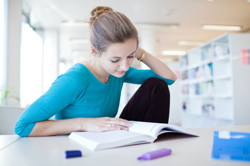 pretty young college student in a library (shallow DOF; color to