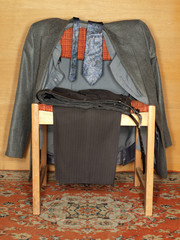 Jacket, pants, shirt and tie on the old chair.